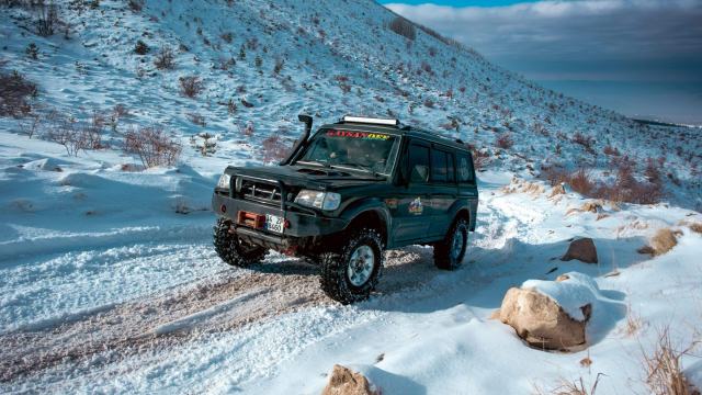 Winter equipment on a mountain road in France Car fitted with snow chains on a snow covered road in the French Alps
